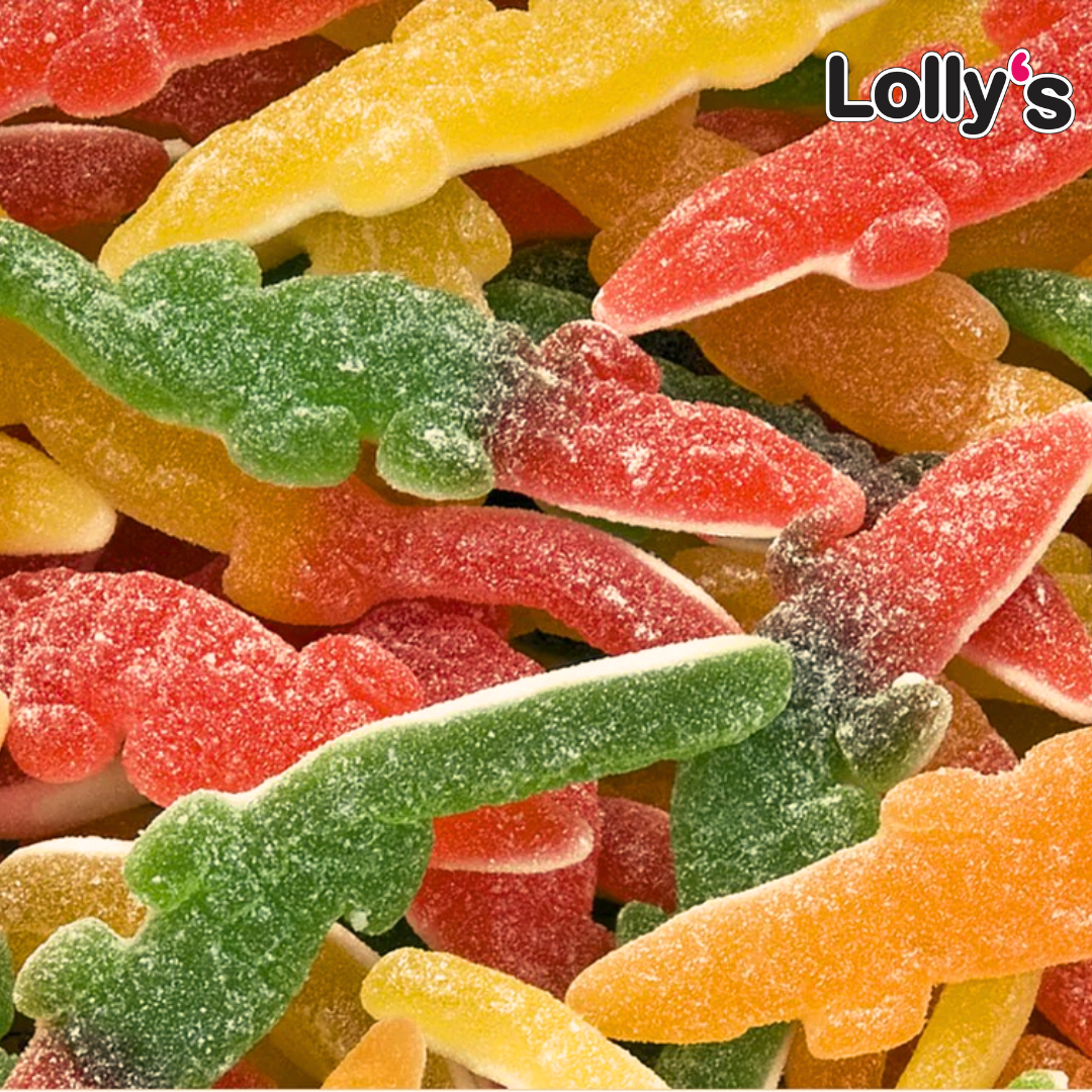 Bonbon en forme de crocodile géant de couleur rouge, jaune, orange et vert en gros plan. Sa texture est gélatineuse et il est entouré de sucre.