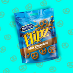 L'image présente un sachet pratique des célèbres snacks sucré salé, les Flipz saveur chocolat au lait. Sur l'emballage bleu brillant, il y a des bretzels recouverts de chocolats au lait. En haut à droite du sachet apparait un bretzel plongeant dans une flaque de chocolat au lait. le logo de la marque est situé en haut à gauche. Il y a également le grammage du sachet (90g). Ce snack est disposé sur un fond bleu clair sur lequel sont disposés des dessins de bretzels.