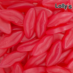 Bonbon en forme de bouche couleur rouge goût tutti frutti en gros plan.