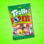 Image d'un sachet dégradé de vert rempli de bonbons en forme d'oeil globuleux. Le sachet est posé sur un font vert fluo.