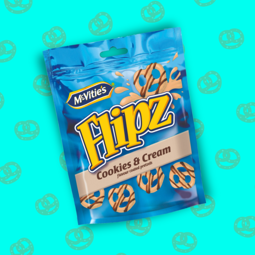 L'image présente un sachet de Flipz Cookies & Cream. Son emballage est bleu (brillant) et jaune. Sur le sachet apparaissent les en-cas enrobés de saveur Cookies & Cream. Des éclats de texture crémeuse apparaissent derrière les bretzels pour véhiculer la sensation crémeuse en bouche. 

