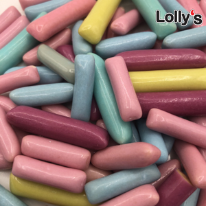 Bonbon en forme de bâtonnet entouré d'une capsule au couleur pastel rose, violette, bleu, jaune, vert en gros plan.