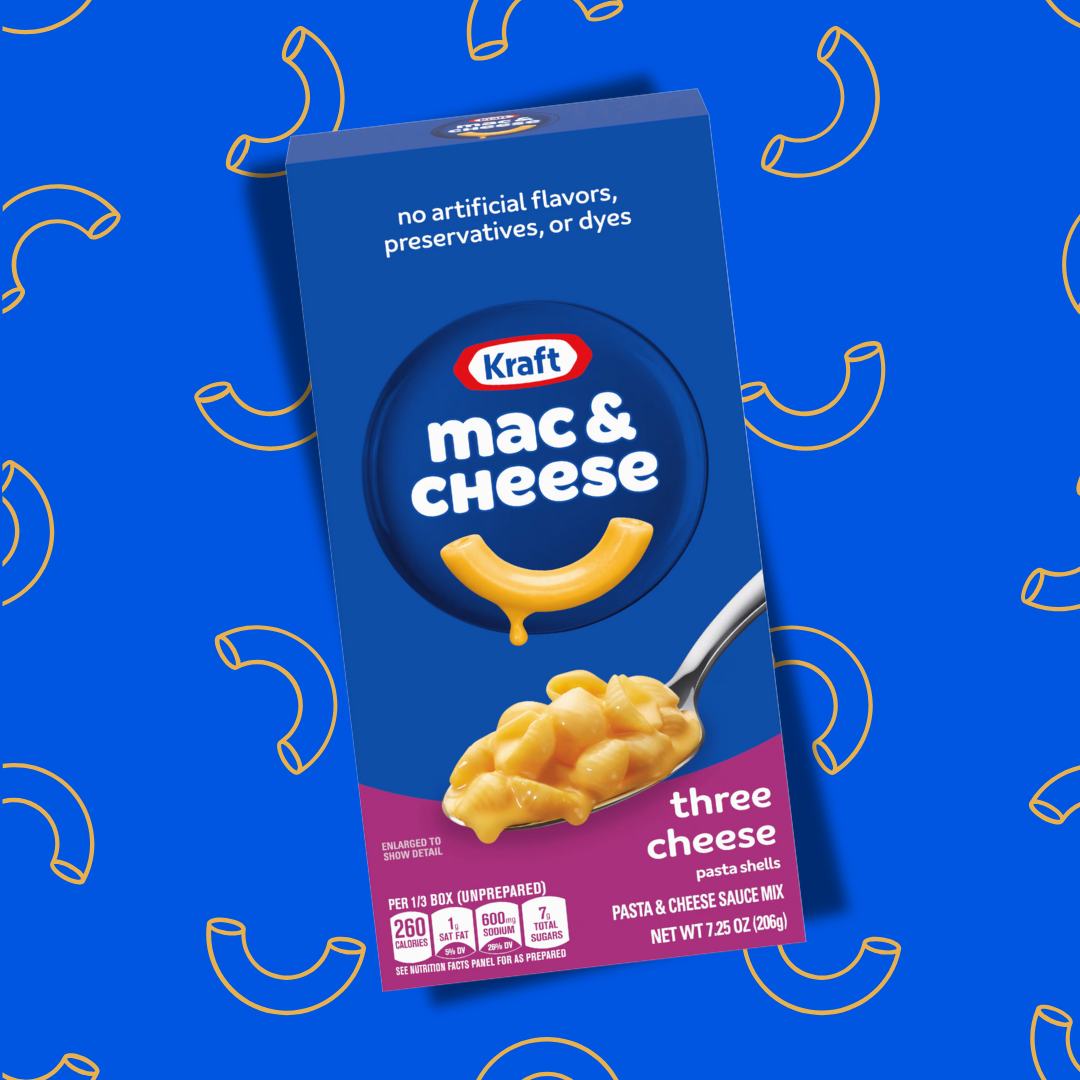 Cette image présente le plat préparé Mac & Cheese saveur trois fromages. Ce plat se présente dans une boîte rectangulaire de couleur bleu et violette. Une cuillère remplie de pâtes Mac & Cheese 3 Cheese présente les pâtes fondantes recouvertes de fromage coulant. Le produit est disposé sur un fond de couleur bleu. 