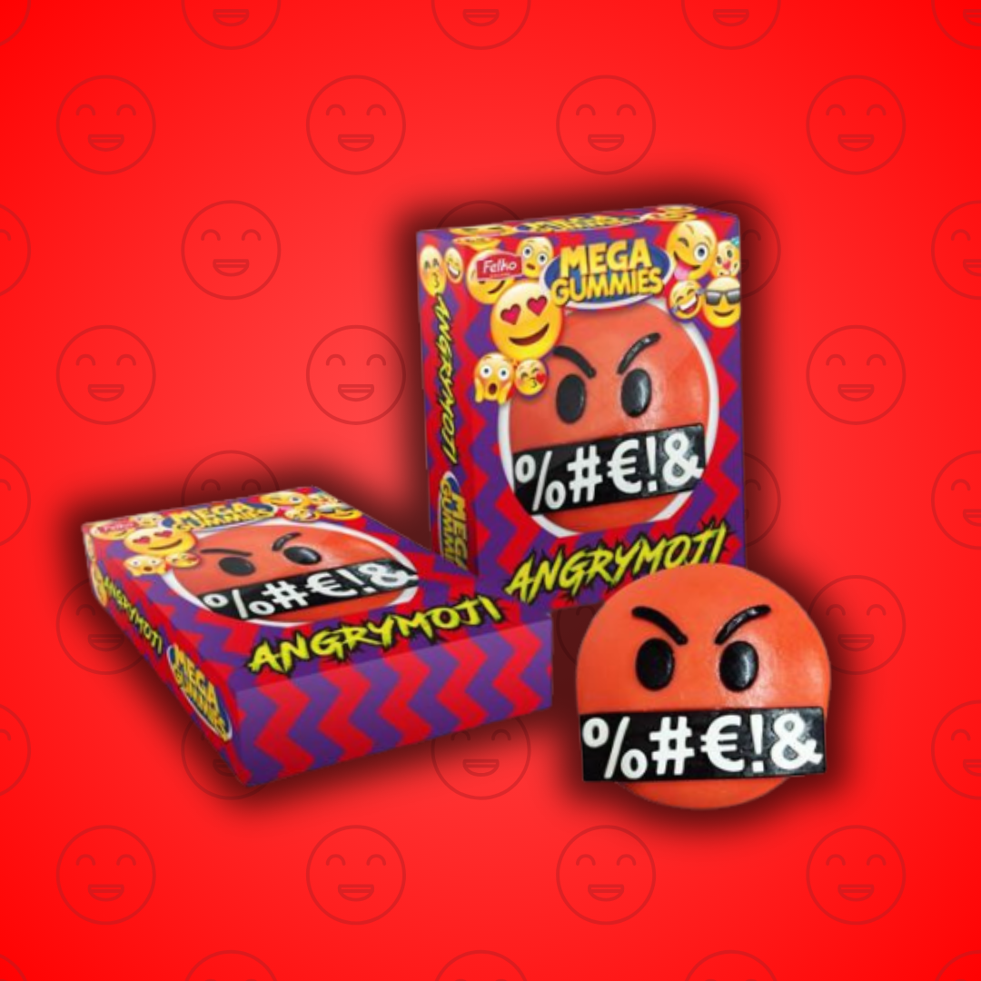 Cette image nous montre un bonbon géant en forme de smiley énervé : le Méga Gummies Angry Moji ! Ce bonhomme très en colère est tout rouge, avec des symboles de dialogues (comme si il prenait la parole). Ce dernier est positionné à coté de sa boite d'emballage, un fond rouge permet de le mettre en valeur. 