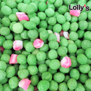 Bonbon petite boule de couleur verte et des petits morceaux de sucres roses en gros plan à l'anis